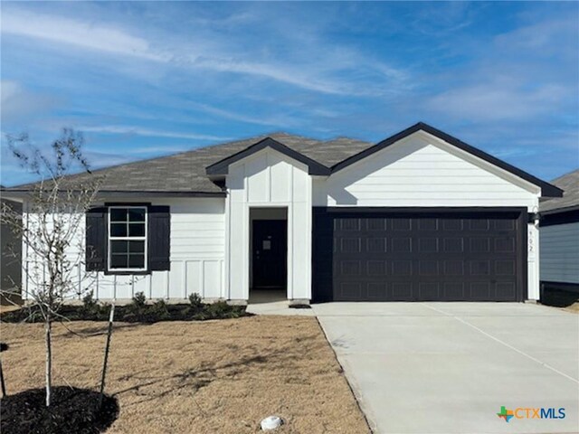 single story home with a front yard and a garage