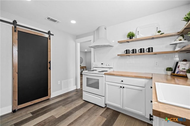 kitchen with butcher block counters, white cabinets, backsplash, white range with electric cooktop, and custom range hood