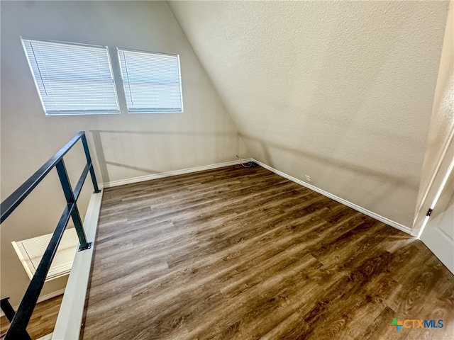 bonus room with hardwood / wood-style floors and vaulted ceiling