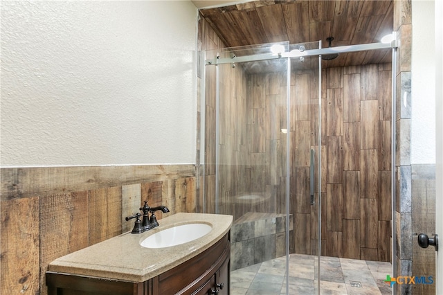 bathroom featuring tile walls, vanity, wooden ceiling, and a shower with shower door