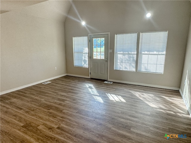 foyer entrance with hardwood / wood-style floors and lofted ceiling