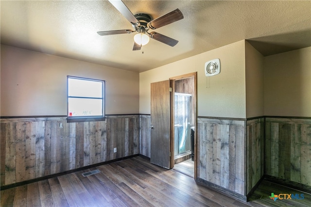 spare room featuring dark hardwood / wood-style flooring, a textured ceiling, and ceiling fan