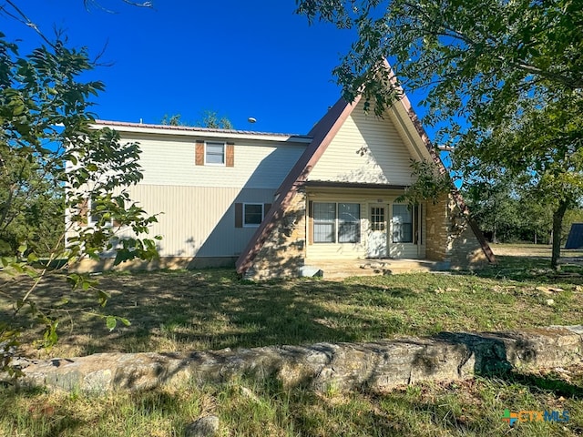 back of property featuring a lawn