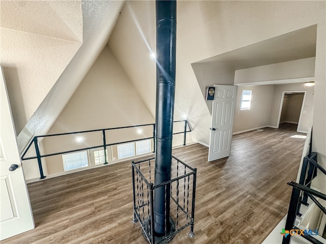 living room featuring dark hardwood / wood-style flooring, vaulted ceiling, and a textured ceiling