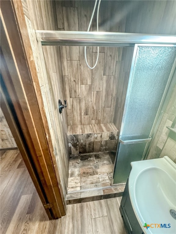 bathroom featuring hardwood / wood-style floors, sink, and an enclosed shower