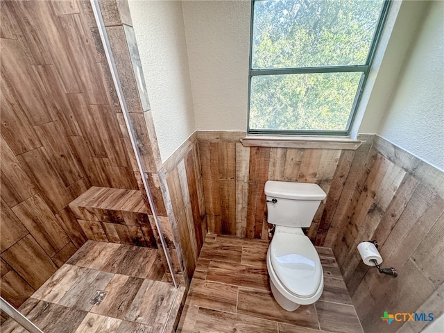 bathroom featuring toilet and tiled shower