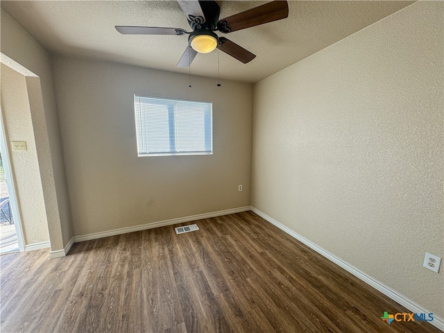 unfurnished room featuring ceiling fan, dark hardwood / wood-style floors, and a textured ceiling