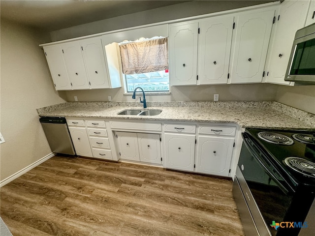 kitchen featuring hardwood / wood-style flooring, appliances with stainless steel finishes, white cabinetry, and sink