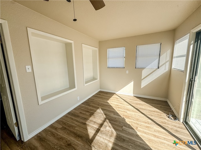 spare room with a textured ceiling, dark hardwood / wood-style floors, and ceiling fan