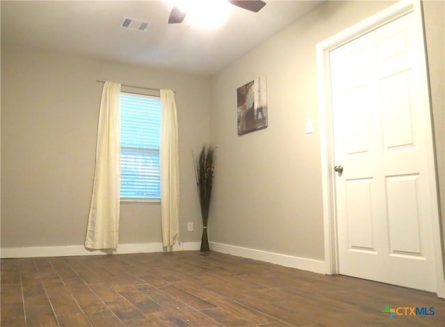 empty room with ceiling fan and dark wood-type flooring