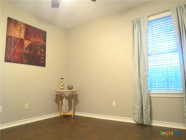 empty room featuring dark hardwood / wood-style flooring and ceiling fan