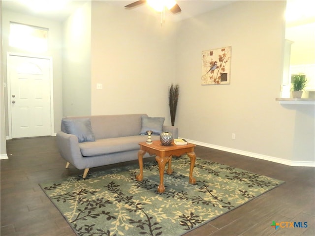 living room featuring ceiling fan and dark hardwood / wood-style flooring