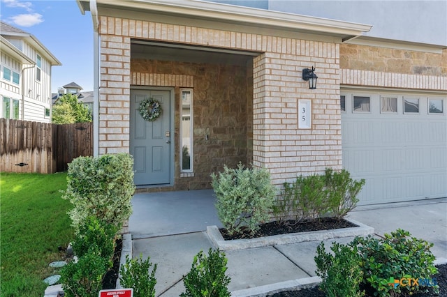 property entrance with a garage and a lawn