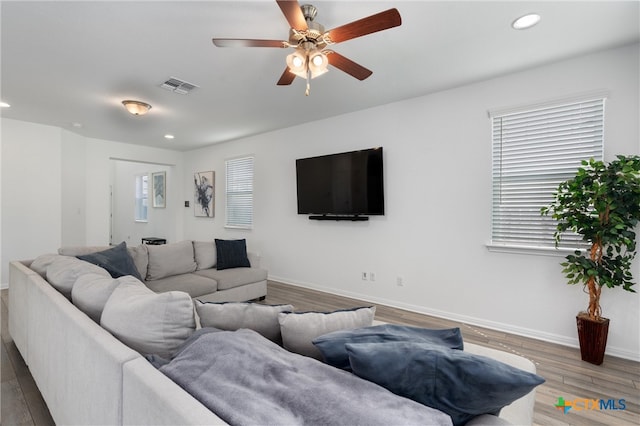 living room featuring wood-type flooring and ceiling fan