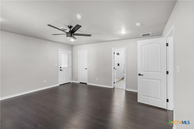 spare room featuring ceiling fan, dark wood-type flooring, and a textured ceiling