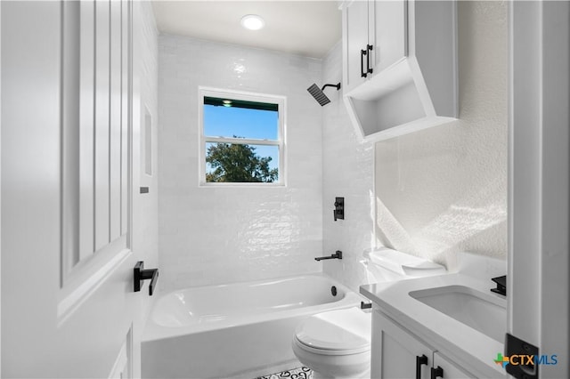 full bathroom featuring vanity, tiled shower / bath combo, and toilet