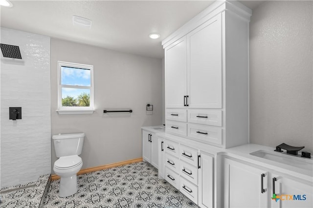 bathroom with tile patterned flooring, a shower, vanity, and toilet