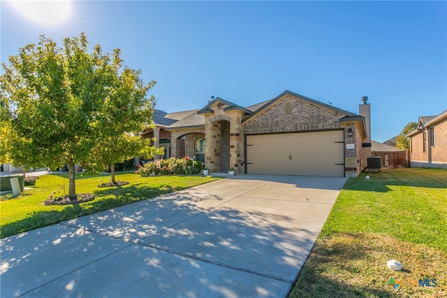 view of front of home featuring central AC unit, a garage, and a front lawn