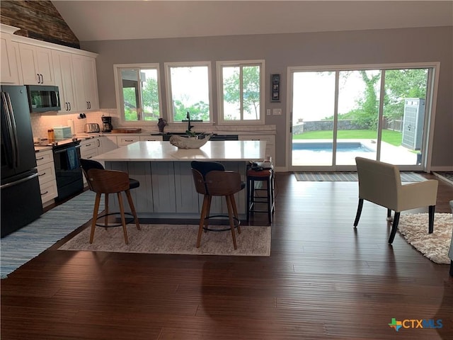164 Buck Ln, Belton, TX 76513 - kitchen featuring black electric range, freestanding refrigerator, lofted ceiling, plenty of natural light, and a center island
