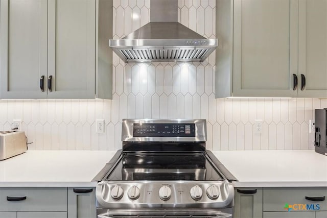 4851 Goliad Dr, Temple, TX 76502 - kitchen with light countertops, tasteful backsplash, stainless steel electric range oven, and wall chimney range hood