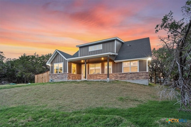 4851 Goliad Dr, Temple, TX 76502 - view of front facade featuring board and batten siding, a front lawn, and brick siding