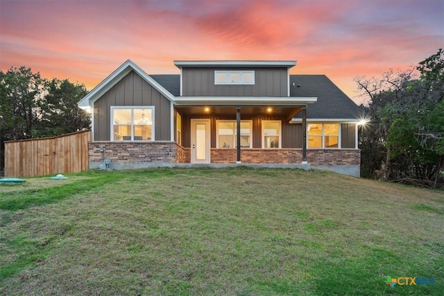 4851 Goliad Dr, Temple, TX 76502 - back of property at dusk featuring a yard, brick siding, and board and batten siding