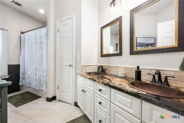 260 County Road 413, Spicewood, TX 78669 - bathroom featuring plenty of natural light, double vanity, and decorative backsplash