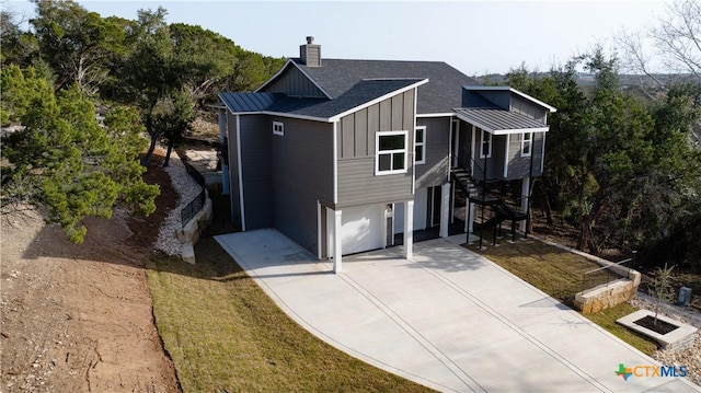20029 Continental Dr, Lago Vista, TX 78645 - view of front of house with board and batten siding, stairway, an attached garage, concrete driveway, and a chimney