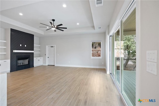 20029 Continental Dr, Lago Vista, TX 78645 - unfurnished living room with a tray ceiling, ceiling fan, baseboards, a large fireplace, and recessed lighting