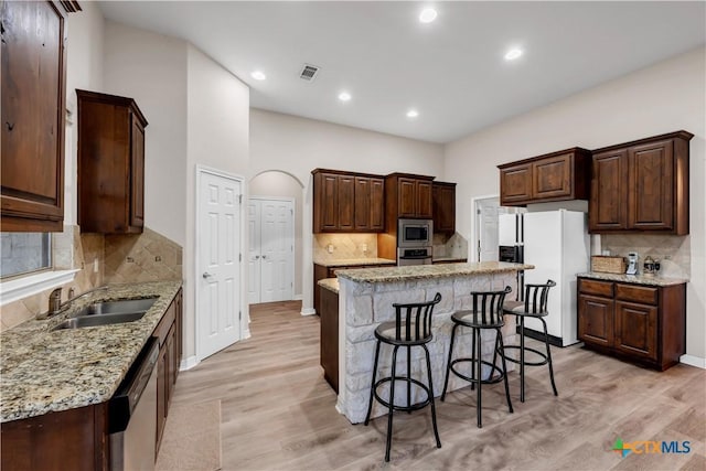 kitchen with a center island, sink, appliances with stainless steel finishes, and light hardwood / wood-style flooring