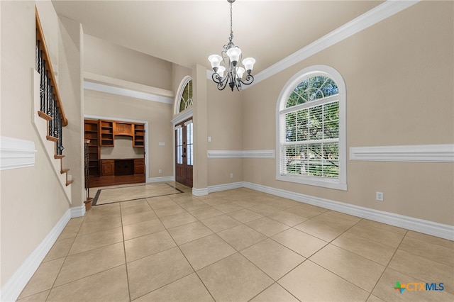 foyer entrance featuring a chandelier, light tile patterned floors, and ornamental molding