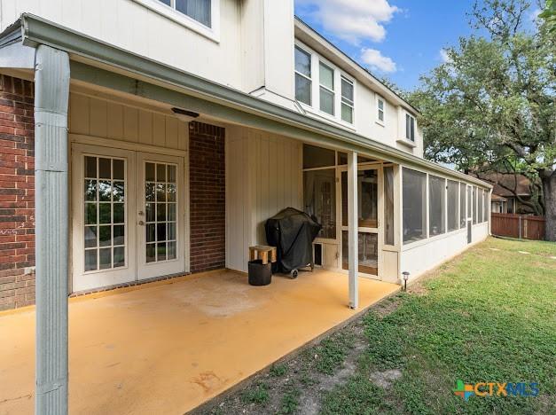 405 Arapaho Dr, Harker Heights, TX 76548 - rear view of property featuring a sunroom, brick siding, and a patio