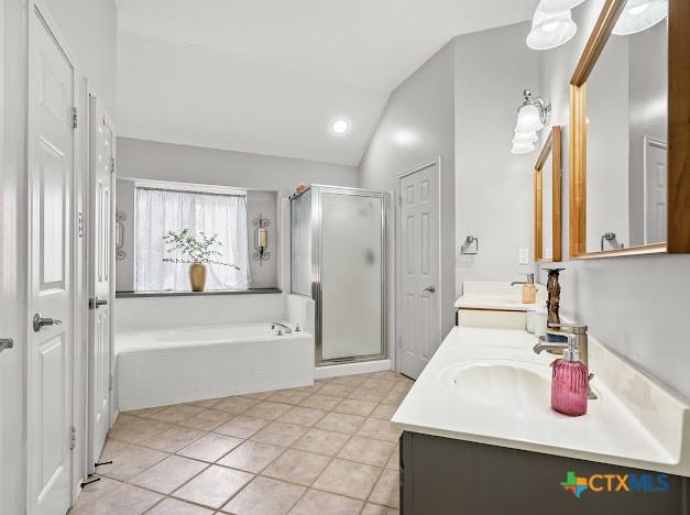 405 Arapaho Dr, Harker Heights, TX 76548 - full bathroom featuring double vanity, a bath, vaulted ceiling, a stall shower, and tile patterned flooring