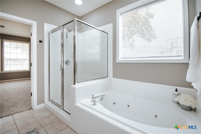bathroom with a jetted tub, tile patterned floors, and a stall shower
