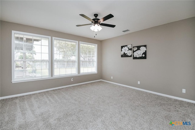 unfurnished room featuring ceiling fan, visible vents, baseboards, and carpet