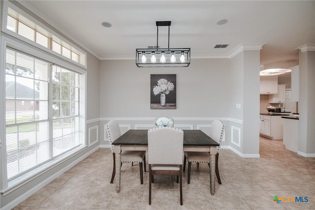 dining area featuring crown molding, light tile patterned floors, wainscoting, and visible vents
