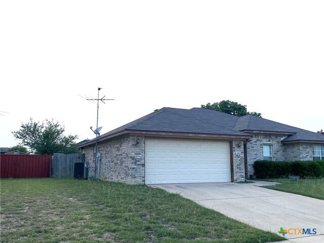 4803 Addie Dr, Killeen, TX 76542 - view of home's exterior with a garage, central AC, driveway, and brick siding