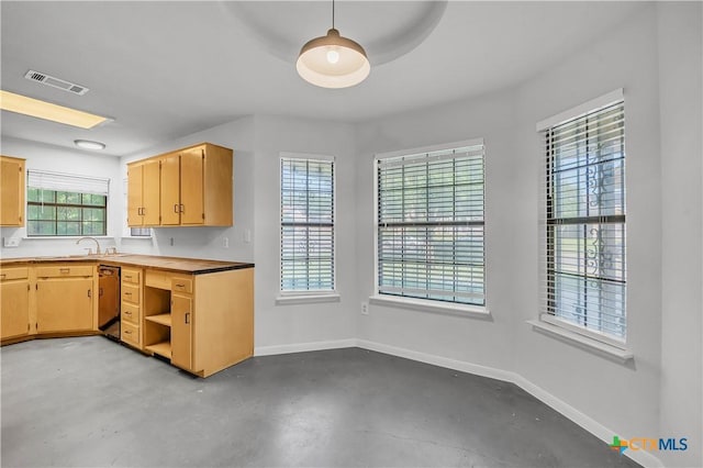 kitchen featuring concrete flooring, baseboards, dishwashing machine, light brown cabinetry, and open shelves