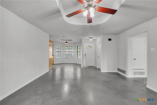 unfurnished living room with baseboards, concrete floors, and ceiling fan
