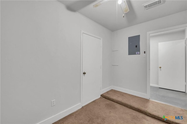 carpeted empty room with electric panel, a ceiling fan, and baseboards