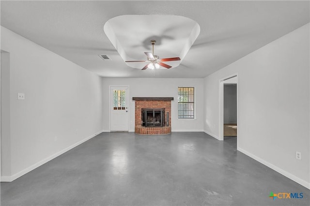 unfurnished living room with a ceiling fan, concrete flooring, baseboards, and a fireplace