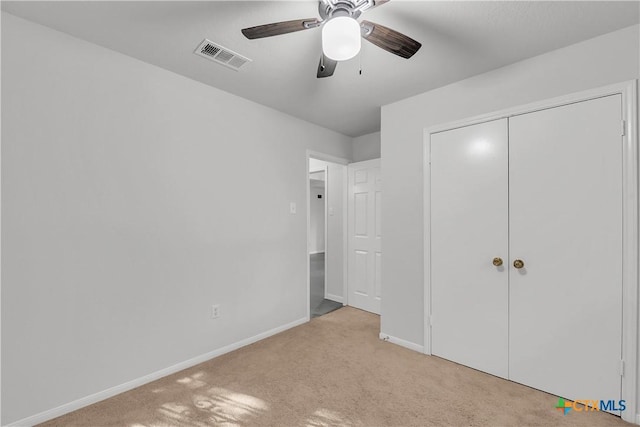 unfurnished bedroom with carpet floors, baseboards, a closet, and a ceiling fan