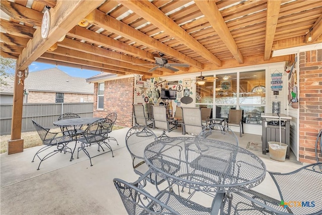 view of patio with ceiling fan, fence, and outdoor dining space