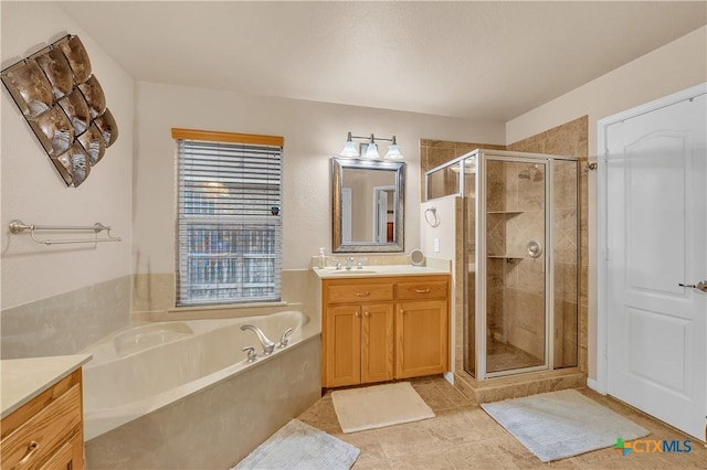 full bath with a stall shower, tile patterned floors, a bath, and vanity