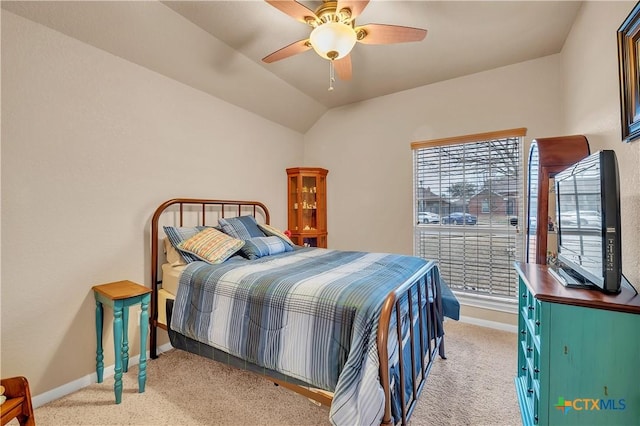 bedroom featuring light carpet, vaulted ceiling, baseboards, and ceiling fan