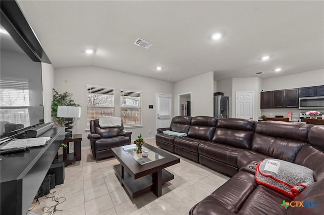 living room with light tile patterned floors and vaulted ceiling