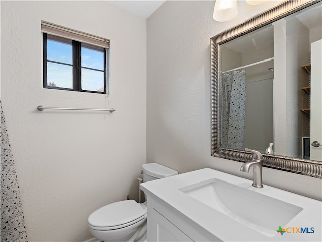 bathroom featuring a shower with curtain, vanity, and toilet