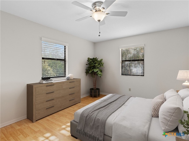 bedroom featuring multiple windows, ceiling fan, and light hardwood / wood-style floors