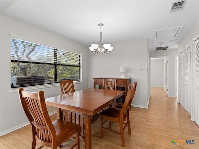 dining space with a notable chandelier and light hardwood / wood-style floors