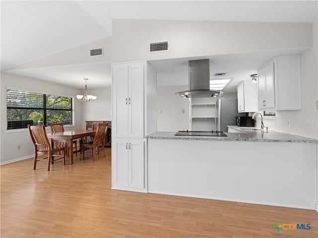 kitchen with white cabinetry, light stone counters, island range hood, and sink